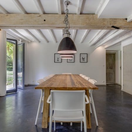 Gite dining area with exposed beams and beautiful lighting